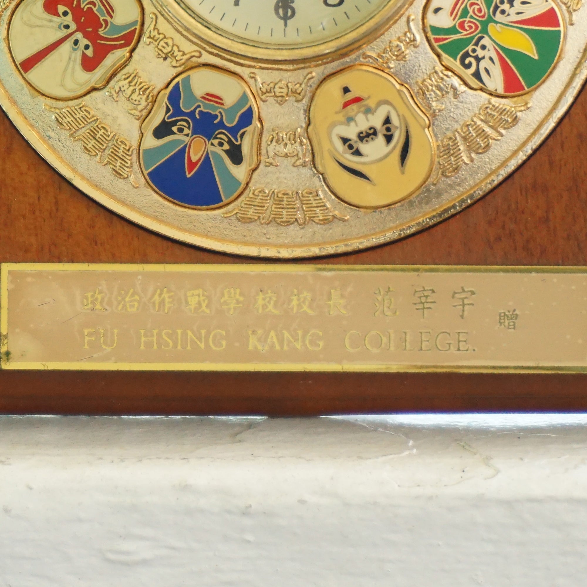 Vintage Fu Hsing Kang College Gold Tone 9 Mask Clock with a Wooden Frame.