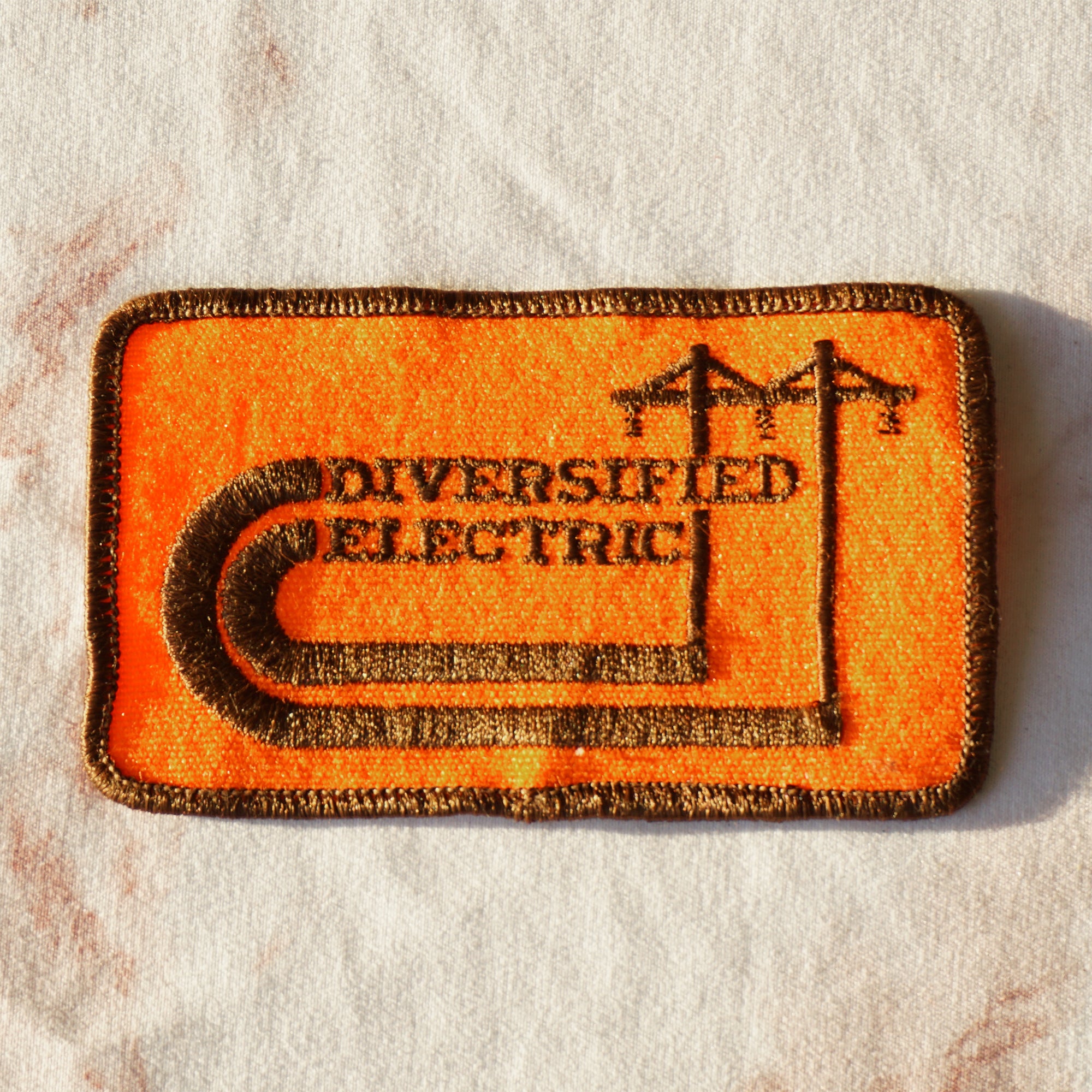 1980s Vintage 4" DIVERSIFIED ELECTRIC Clothing Patch. Orange and Brown Colors.