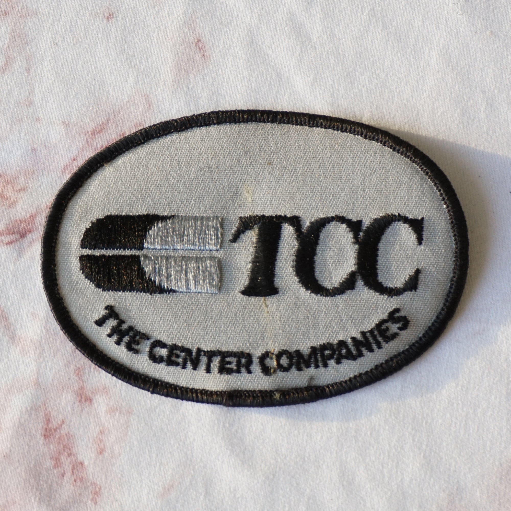 1980s Vintage 4" TCC The Center Companies Clothing Patch. Black and Grey Colors.