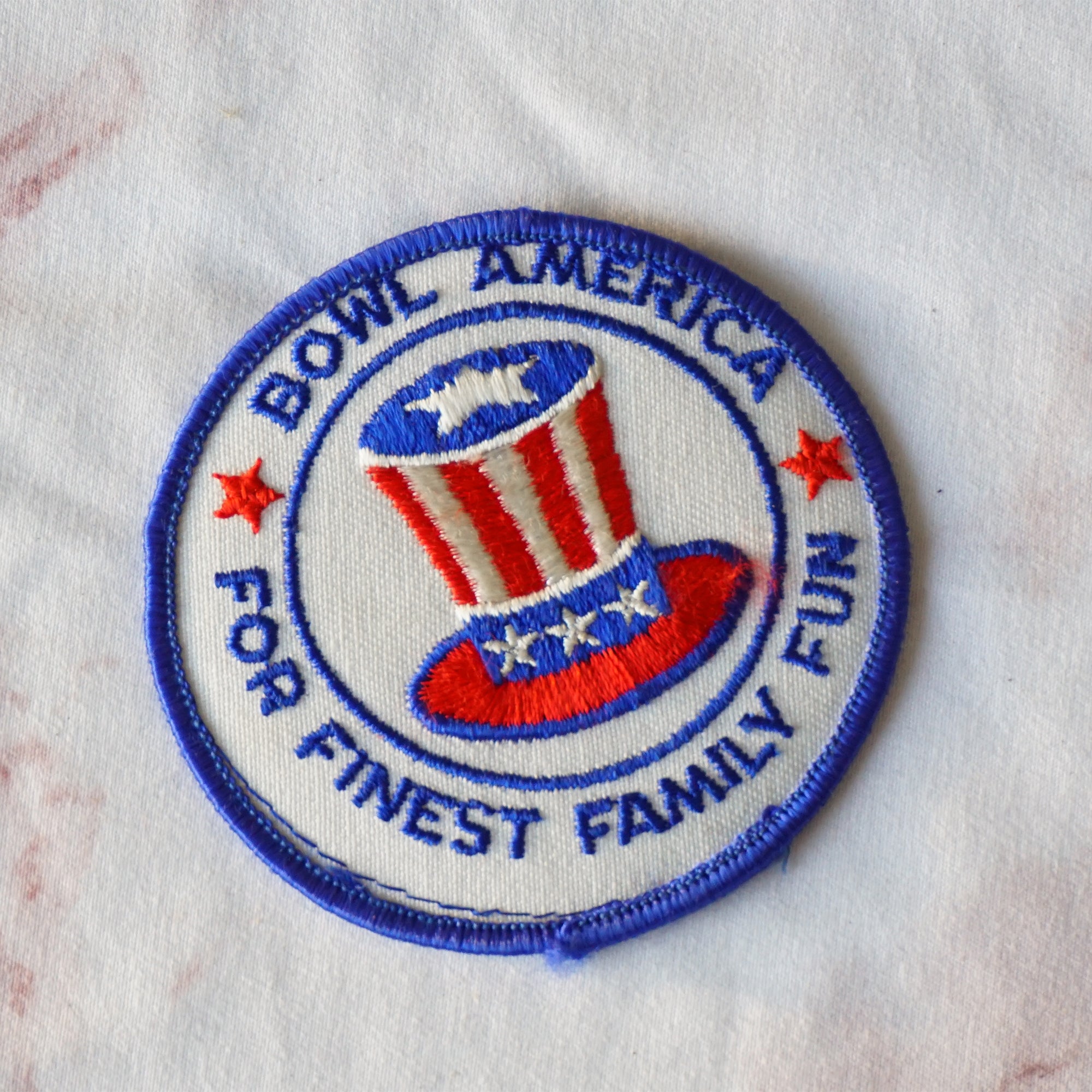 1980s Vintage 3" Bowl America For Finest Family Fun Clothing Patch with Flag Top Hat. Blue, Red and White Colors.